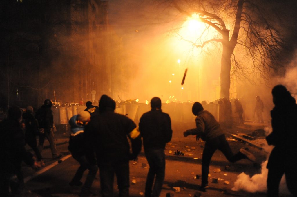 Protestors launch any available projectiles at walls of riot police on a smoky January night in Ukraine. (Wikimedia Commons)